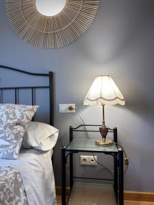 a table with a lamp on it next to a bed at Apartamento La Emisora in Ponferrada