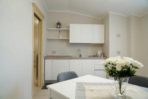 una cocina con una mesa con un jarrón de flores. en Donna Filu Casa Vacanze, en Santa Maria La Carità