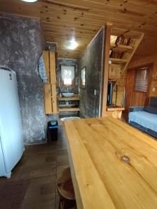 a large wooden table in a room with a bed at Pousada Vale da Imbuia chalé para temporada in Urubici