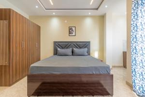 a bedroom with a large bed and a wooden cabinet at Wandr Regor - Sector 38, Near Medicity Medanta in Gurgaon