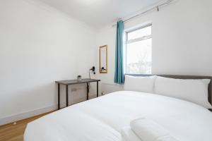 a white bedroom with a bed and a window at Stratford Double Rooms - 29 in London