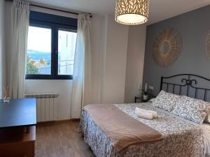 ein Schlafzimmer mit einem Bett und einem großen Fenster in der Unterkunft Apartamento La Emisora in Ponferrada