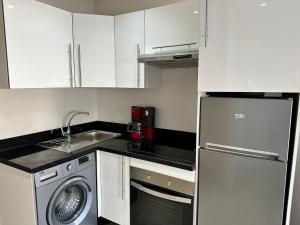 a kitchen with white cabinets and a washing machine at Dar Esslam Studio Moderne in Casablanca