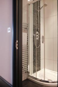 a bathroom with a shower with a glass door at Rose and Crown Stoke Newington in London