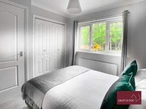 ein Schlafzimmer mit einem weißen Bett und einem Fenster in der Unterkunft Knaphill - 2 Bed House - Private Garden & Parking in Brookwood