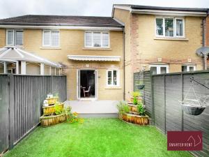 a backyard with a fence and a house at Knaphill - 2 Bed House - Private Garden & Parking in Brookwood