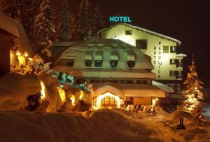 a hotel is lit up in the snow at night at Hotel Pahuljica in Vlasic