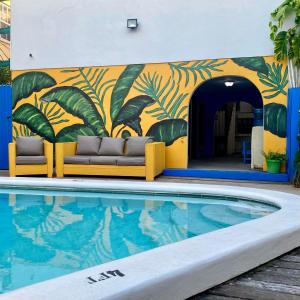 mural de una piscina en un edificio con sofá en Seven Seas Resort Adults Only, en San Pedro