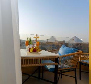 a table with a plate of fruit on a balcony at Diamond Pyramids View Inn in Cairo
