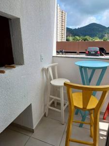 een klein balkon met een tafel en 2 stoelen bij Apartamento em Itapema- 10k de Balneário Camboriú in Itapema