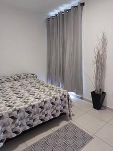 een slaapkamer met een bed en een potplant bij Apartamento em Itapema- 10k de Balneário Camboriú in Itapema