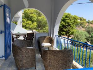uma varanda com cadeiras de vime e uma mesa com vista em Beautiful summer house 5' from the beach em Karafotaíika