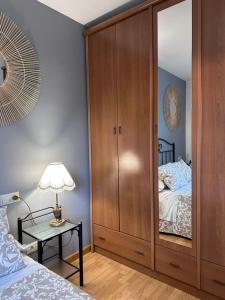 a bedroom with a large wooden cabinet next to a bed at Apartamento La Emisora in Ponferrada