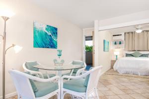 a dining room with a table and chairs and a bedroom at ***SERENDIPITY ON THE MOANA - Legal & Oceanfront - Great for Work & Play!*** in Waianae