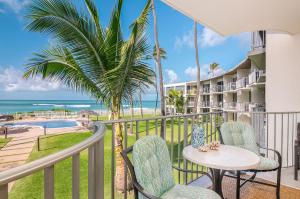 a balcony with chairs and a table and a view of the beach at ***SERENDIPITY ON THE MOANA - Legal & Oceanfront - Great for Work & Play!*** in Waianae