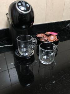 a coffee maker and two cups on a counter at Flat Gramado Home Sweet Home in Gramado