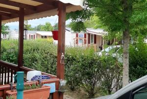 eine Veranda mit einer Pergola und einem Haus in der Unterkunft Bungalow de 3 chambres avec piscine partagee jardin amenage et wifi a Onzain in Onzain