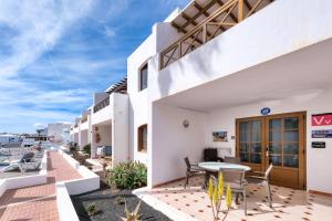 - une vue sur la cour d'un hôtel avec une table et des chaises dans l'établissement Casa Appia-300m from the beach, heated pool, à Puerto del Carmen