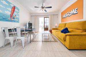 uma sala de estar com um sofá amarelo e uma mesa em Casa Appia-300m from the beach, heated pool em Puerto del Carmen