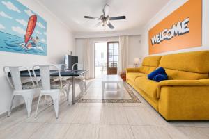 a living room with a yellow couch and a table at Casa Appia-300m from the beach, heated pool in Puerto del Carmen