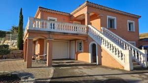 ein Backsteinhaus mit einem Balkon und einer Garage in der Unterkunft Logement au calme, avec vue dégagée in Ardoix
