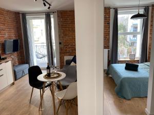 un appartamento monolocale con una camera da letto, un letto e un tavolo di Konarskiego Residence a Cracovia
