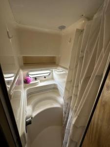 a small room with a bath tub and curtains at Le Grand Bleu - idéal Festival de Cannes in Cannes