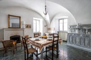 comedor con mesa, sillas y chimenea en Historic Italian House in Val Grande near Lake Maggiore, en Premosello Chiovenda