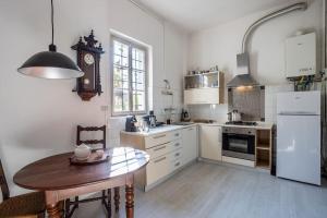 a kitchen with a table and a clock on the wall at Historic Italian House in Val Grande near Lake Maggiore in Premosello Chiovenda +30 photos