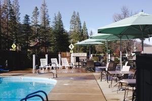 - une piscine avec des chaises, des tables et des parasols dans l'établissement Flagship Inn of Ashland, à Ashland