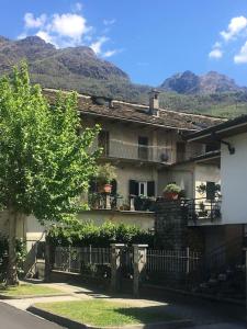 una casa con una valla y montañas en el fondo en Historic Italian House in Val Grande near Lake Maggiore, en Premosello Chiovenda