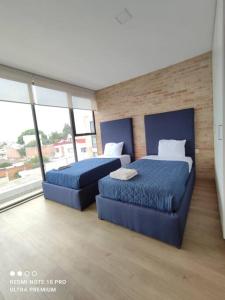 - 2 lits dans une chambre avec des draps bleus et des fenêtres dans l'établissement Increíble PH en Cholula centro, Puebla, à Cholula