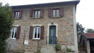 a stone house with red windows and a door at La clef des champs - Gîte 9 personnes entre Lyon et St-Etienne in Les Halles