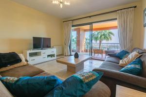 een woonkamer met 2 banken en een televisie bij Royal Flamingos Sea View Apartman in Estepona