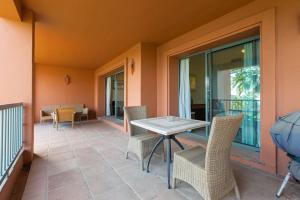 een patio met een tafel en stoelen op een balkon bij Royal Flamingos Sea View Apartman in Estepona