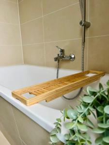a wooden shelf on a bath tub in a bathroom at Gemütliches Apartment in zentraler Lage in Hamburg Alsterdorf für bis zu 7 Personen in Hamburg