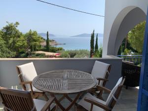 uma mesa e cadeiras numa varanda com vista para o oceano em Beautiful summer house 5' from the beach em Karafotaíika