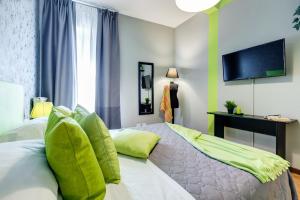 - une chambre avec un lit doté d'oreillers verts et une télévision dans l'établissement Ghetto apartment, à Rome