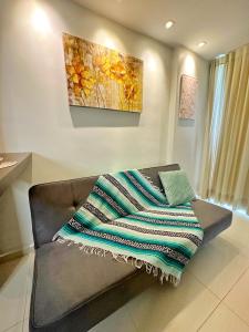 a couch with a blanket on it in a room at Maravilhoso Apartamento em Brasília DF in Brasilia