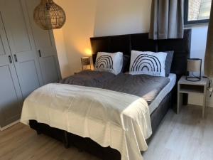 a bedroom with a large bed with two pillows at De Ceder in Soesterberg