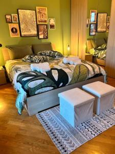 - une chambre avec un grand lit et deux tabourets dans l'établissement Vita lenta Garbatella, à Rome
