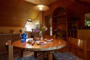 una cocina con una mesa de madera y un jarrón de flores en Wild Valley Village Life Apartment in Onsernone, en Loco