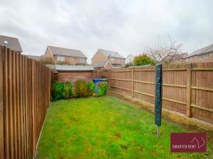a backyard with a wooden fence and a yard at Bracknell - 2 Bedroom House With Garden in Bracknell