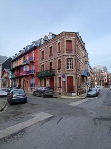 una calle con coches estacionados frente a un edificio en NOUVEAU: Charmant appartement de 35m², en Mers-les-Bains