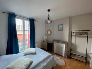 een slaapkamer met een bed en een raam bij NOUVEAU: Charmant appartement de 35m² in Mers-les-Bains