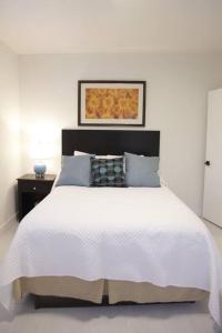 um quarto branco com uma cama branca e uma cabeceira preta em Apt 2 Miami Designer Apartment in the Upper East-Side em Miami