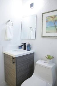 uma casa de banho branca com um lavatório e um WC em Apt 2 Miami Designer Apartment in the Upper East-Side em Miami