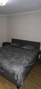 - un lit avec une couette en noir et blanc dans une chambre dans l'établissement Résidence appartement Oostende, à Ostende