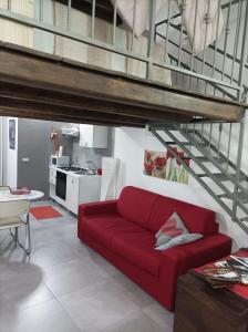 un sofá rojo en una sala de estar con un loft en LA CASETTA DI MARTA ai Quattro Canti di Giusi, en Palermo