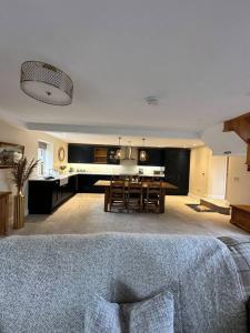 a living room with a kitchen and a dining room at Converted Barn with Hot Tub, The Hayloft. in Over Kellet